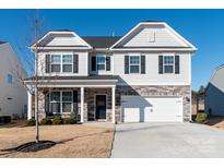 Two-story house with gray siding, stone accents, and a white garage door at 4479 Dover Ct, Denver, NC 28037