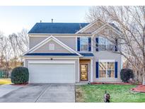 Two-story house with taupe vinyl siding, white garage door, and landscaping at 4649 Maple Crest Pl, Harrisburg, NC 28075