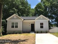 Newly constructed charming house with gray siding, a neatly landscaped yard and driveway at 5-1/2 B Seminole St, Gastonia, NC 28054