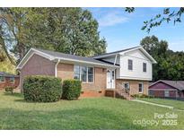 Brick ranch home with a landscaped yard and white accents at 6762 Glenmoor Dr, Charlotte, NC 28214