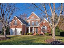 Brick two-story house with a three-car garage and manicured landscaping at 819 Lillieshall Rd, Waxhaw, NC 28173