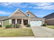 Brick front exterior of charming craftsman style home with 2-car garage at 8243 Bretton Woods Dr, Charlotte, NC 28227