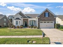 Beautiful two-story home with stone accents and a landscaped lawn at 9124 Longvale Ln, Charlotte, NC 28214