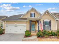 Tan two-story house with a white garage door and landscaping at 1009 Chapman St, Indian Trail, NC 28079