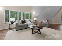 Comfortable living room with natural light from large windows, featuring neutral tones and stylish furnishings at 10200 Amsterdam Dr, Mount Pleasant, NC 28124