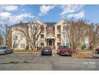 Brick condo building with ample parking and landscaping at 10240 Rose Meadow Ln # D, Charlotte, NC 28277