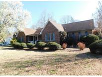 Charming one-story brick home featuring a well-manicured lawn, mature trees, and classic architectural details at 110 Robin Rd, Lincolnton, NC 28092