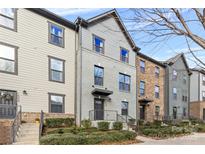 Three-story townhouses with brick and siding exteriors, showcasing landscaping and walkways at 1554 Kee Ct, Charlotte, NC 28203