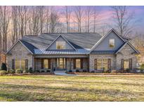 Two-story brick home with gray accents and a metal roof at 200 Barra Dr, Waxhaw, NC 28173