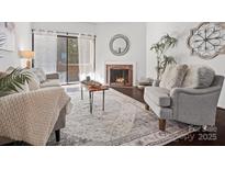 Cozy living room features fireplace, hardwood floors, and comfy seating at 224 N Poplar St # 22, Charlotte, NC 28202