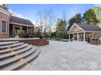 Brick patio with pool, spa, and outdoor kitchen at 6049 Bluebird Hill Ln, Weddington, NC 28104