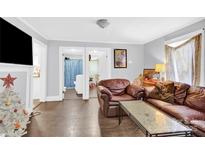 Living room with brown leather couch and view of bathroom at 911 Elm St, Kannapolis, NC 28081