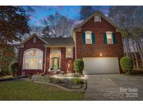 Charming brick home featuring a well-manicured lawn and an attached two-car garage at 1000 Weeping Willow Ln, Matthews, NC 28105