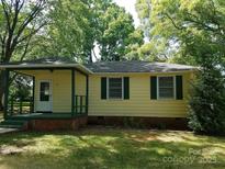 Ranch style home features a covered porch and well-maintained lawn at 1418 Winston Dr, Charlotte, NC 28205