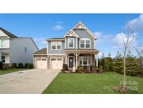 Two-story house with gray siding, stone accents, and a two-car garage at 1585 Whitman Ct, York, SC 29745