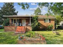 Charming brick home with a covered front porch and a small garden, creating a welcoming curb appeal at 1901 Ashcraft Ave, Monroe, NC 28110