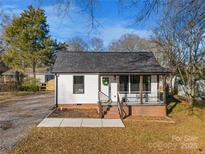 White house with gray roof, front porch, and landscaped yard at 30 Walnut Nw Ave, Concord, NC 28027