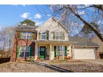 Two-story brick home with green shutters, attached garage, and landscaped yard at 502 Long Creek Pkwy, Charlotte, NC 28214