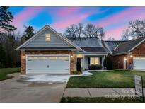 One-story home with gray siding, stone accents, and a two-car garage at 629 Cordova Ct, Salisbury, NC 28146