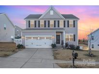 Two-story house with gray siding, white trim, and a three-car garage at 7067 Waterwheel Sw St, Concord, NC 28025