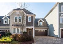 Two-story townhome with gray siding, brown garage door, and brick driveway at 7908 Rea View Ct, Charlotte, NC 28226