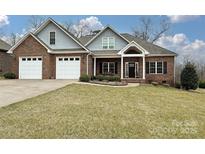 Charming brick home featuring a three-car garage and well-manicured front lawn at 1467 Kensington Park Ct, Hickory, NC 28602