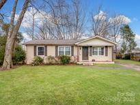 Ranch style home with a well-maintained lawn and mature trees at 1500 Collier Ct, Charlotte, NC 28205