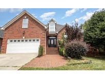 Brick house with a two-car garage and landscaped front yard at 1610 Elkhart Cir, Gastonia, NC 28054