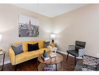 Cozy living room with a yellow couch, dark wood floors, and a decorative coffee table at 1620 #G Arlyn Cir # G, Charlotte, NC 28213
