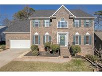 Brick two-story house with green shutters, landscaping, and a two-car garage at 4225 Nathaniel Glen Ct, Matthews, NC 28105