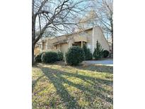 Tan two-story home with landscaping and trees in front at 1017 N Center Nw St, Hickory, NC 28601