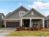 Gray-toned house with stone accents, two-car garage, and manicured lawn at 1115 Millview Ln, Matthews, NC 28104