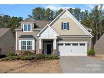 Two-story house with neutral siding, white garage door, and landscaping at 116 Van Gogh Trl, Mount Holly, NC 28120