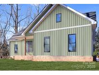 Modern craftsman style home with light green siding and brick accents at 1212 Donna Dr, Shelby, NC 28152