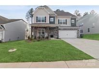 Two-story home with stone accents and a large front yard at 146 Dogwood Grove Pl, Troutman, NC 28166