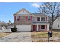 Two-story brick home with a white garage door and red accents at 709 Ferrell Ave, Charlotte, NC 28216