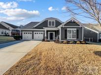 Gray two-story house with two-car garage and landscaped lawn at 12211 Bonny Oaks Dr, Cornelius, NC 28031