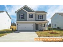 Two-story house with gray and white siding, two-car garage, and landscaped yard at 6308 Honor Ave, Midland, NC 28107