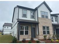 Charming two-story home featuring a brick facade, light gray siding, and professionally landscaped front yard at 3103 Beacon Heights Rd, Indian Land, SC 29707