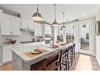 Modern kitchen with white cabinets, island, and stainless steel appliances at 5033 Westmead Ln, Charlotte, NC 28262