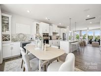Bright dining area features a modern table and chairs next to the open-concept kitchen at 5037 Westmead Ln, Charlotte, NC 28262