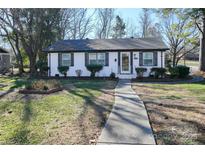 Charming single-story home with a tidy front yard and a walkway leading to the front door at 1233 Rollingwood Dr, Charlotte, NC 28217