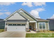 Two-story house with a neutral color scheme, two-car garage, and landscaping at 14207 Asbury Park Rd, Huntersville, NC 28078