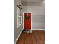 Inviting entryway with red door, wreath, and wood floors at 201 Hoskins Rd # 115, Charlotte, NC 28208
