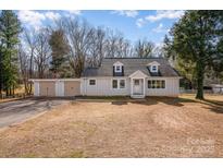 Charming single-story home featuring a detached two-car garage with a basketball hoop and mature trees at 2752 Peachtree Rd, Statesville, NC 28625