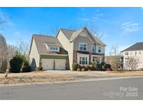 Charming two-story home features a two-car garage, stone accents, and lush landscaping at 334 Cotton Field Rd, Indian Land, SC 29707