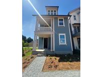 Charming blue two-story home with a covered porch, detailed landscaping, and inviting curb appeal at 421 Delburg Mill Alley Dr, Davidson, NC 28036