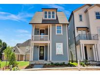 Charming two-story blue home with a front porch and a well-manicured yard at 421 Delburg Mill Alley Dr, Davidson, NC 28036