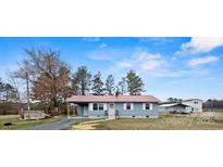 Charming single-story home with a red roof, a carport, and a well-maintained front yard at 4926 Nc Highway 109 South, Mount Gilead, NC 27306