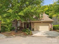 Brick home with 2-car garage, mature trees, and landscaping at 10607 Newberry Park Ln, Charlotte, NC 28277
